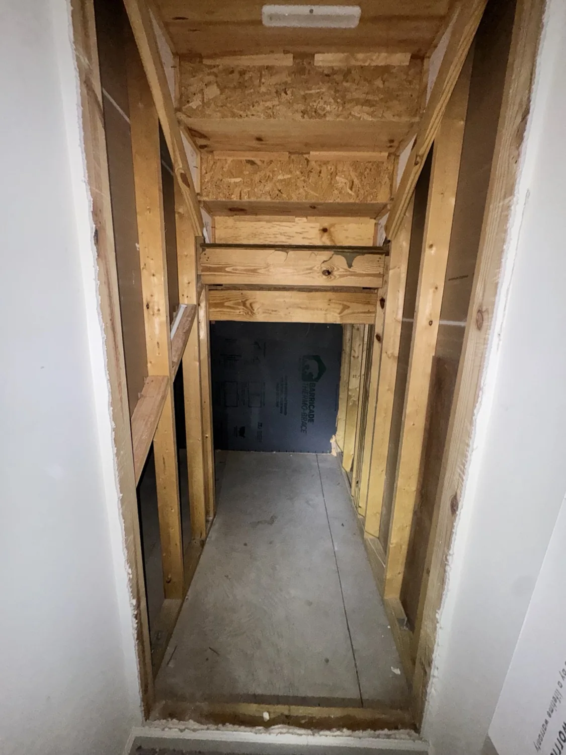 During renovation: wall opened to reveal framing and space beneath the stairs